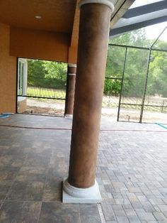 an empty patio with columns and tiled flooring