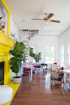 a living room filled with furniture and a fire place next to a fireplace covered in plants