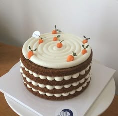 a cake with white frosting and carrots on top