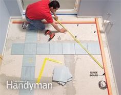 a man laying tile on the floor with tools