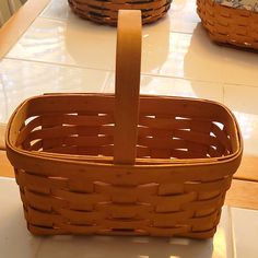 two wicker baskets sitting on top of a white tiled floor next to each other