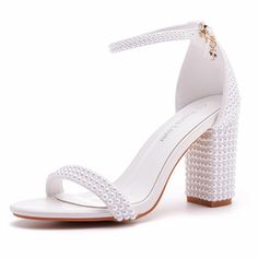 a white high heeled sandal with pearls