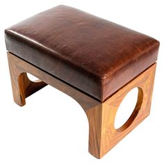 a brown leather ottoman sitting on top of a wooden frame