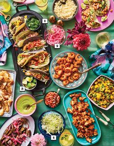 a table full of food including tacos, cornbreads and other foods on it