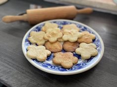 some cookies are on a blue and white plate with a rolling pin in the background