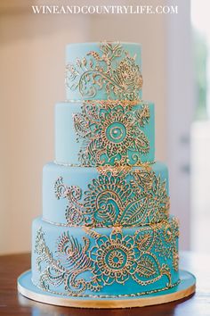 a blue and gold wedding cake sitting on top of a table