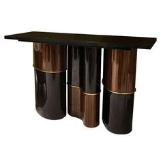 three black and gold vases sitting on top of a wooden table next to each other