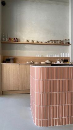 a counter with plates and cups on it in a room that has shelves above the counter