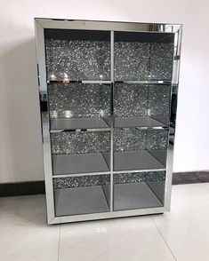 a large mirrored display case with silver glittered glass shelves on the front and sides