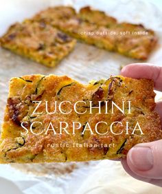 someone holding up a piece of food with the title zucchini scarpacca