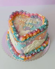 a heart shaped birthday cake sitting on top of a table