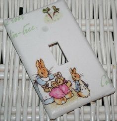 a white light switch cover with two rabbits on it