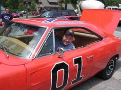 a man sitting in the driver's seat of a red car with number 11 on it