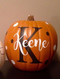 two pumpkins with the letter k painted on them are sitting next to each other