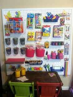 a peg board with some toys on it and two chairs in front of the table