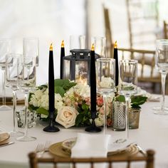 a table set with candles, flowers and napkins for an elegant dinner or party