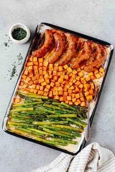 an assortment of vegetables and meats on a baking sheet