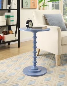 a blue table with a clock on it in a living room next to a couch