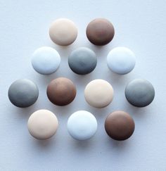 several different colored rocks arranged in a circle on a white table top with one being smaller than the other