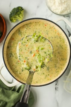 broccoli and cheese soup in a pot with a ladle on the side