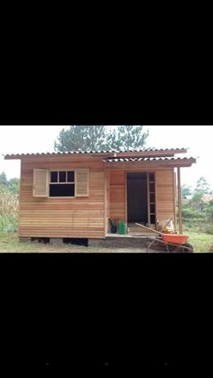 a small wooden house sitting in the middle of a field