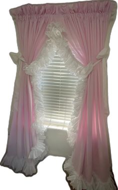 the window is decorated with pink and white ruffled curtains