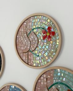 four circular mosaics are hanging on the wall