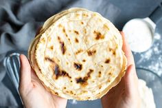 a person holding a tortilla in their hands