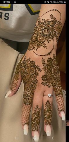 a woman's hand with henna tattoos on it