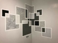 a bathroom with white walls and black squares on the wall