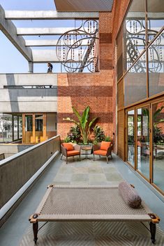 an outdoor patio with chairs and tables in the center, surrounded by glass walls that lead to two levels