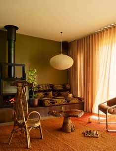 a living room filled with furniture and a fire place next to a window covered in curtains