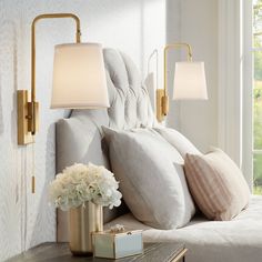 a bed with pillows and lamps on top of it