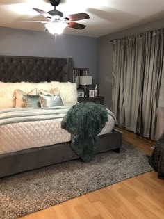 a bedroom with a bed, rugs and ceiling fan in it's center