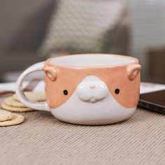 a cup with a face on it sitting next to crackers