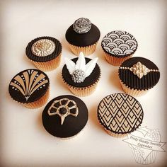 an assortment of decorated cupcakes sitting on top of a table