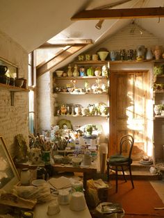 a room filled with lots of pots and pans next to a fire place in a building