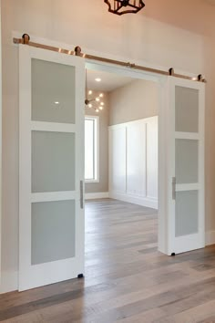 an empty room with sliding doors and hard wood flooring on either side of the door