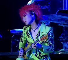 a woman with red hair playing an electric guitar