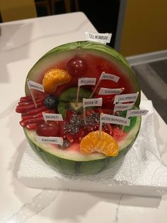 a watermelon filled with fruits and vegetables on top of a white countertop