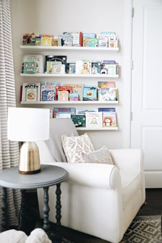 a living room with white furniture and bookshelves on the wall above it's couch