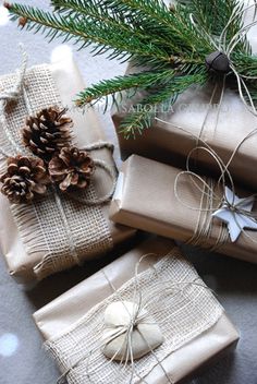 christmas presents wrapped in burlap and tied with twine, pine cones and holly