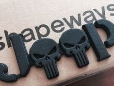 a close up of the word slapews with three skulls on it's side