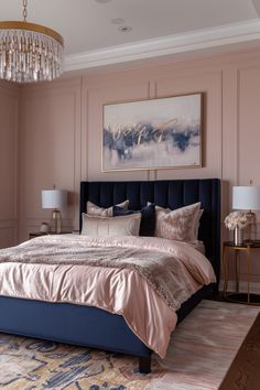 a large bed sitting under a chandelier next to a painting on the wall