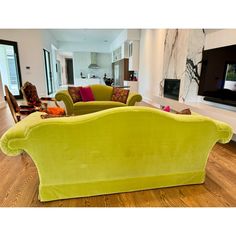 a living room filled with furniture and a flat screen tv mounted on the wall above it