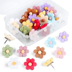 small flower shaped pins in a plastic container