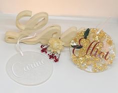 two wooden ornaments are sitting on a white table with the word love spelled in gold letters