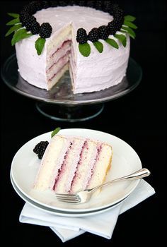 two slices of cake with berries on top and one slice cut out from the cake