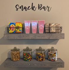 some snacks and drinks are sitting on the shelves in front of the sign that says snack bar