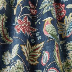 a close up view of a blue fabric with colorful flowers and birds on the side